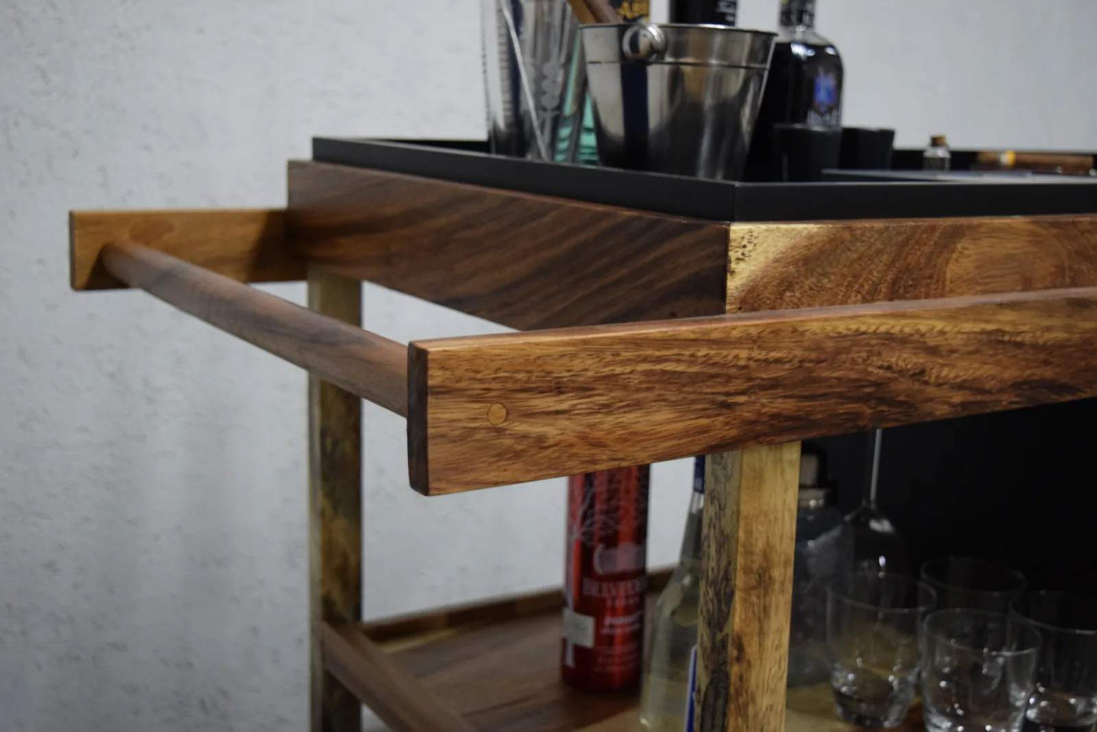 Detalle de carrito de bar de madera con barra cromada
